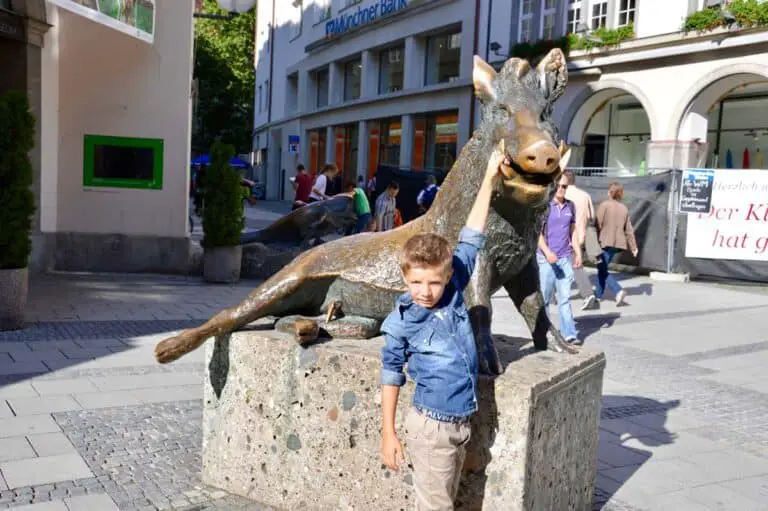 bambino vicino alla Statua del porcellino