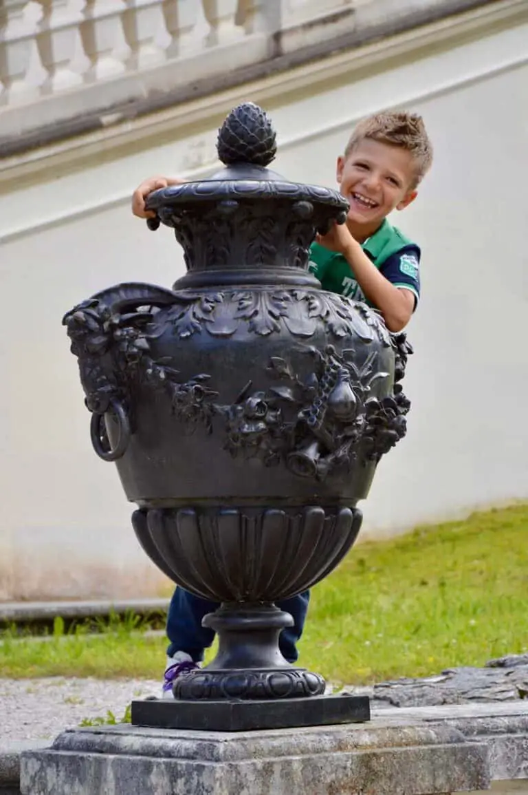 bambino che gioca dietro ad un vaso