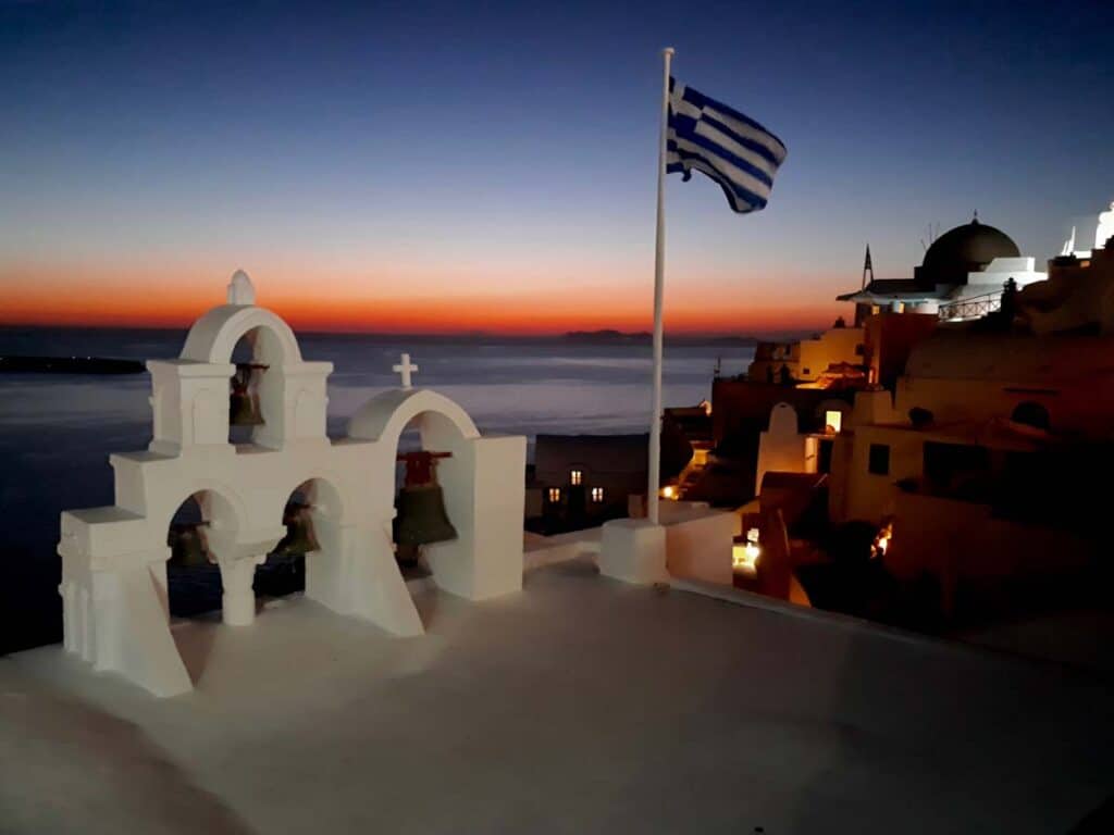 Tramonto a Santorini 20 Panorama di Santorini con bandiera della Grecia